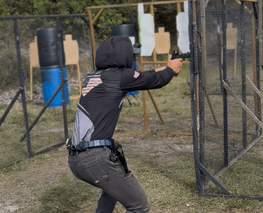 A competitor engaging steel targets with a compensated open pistol